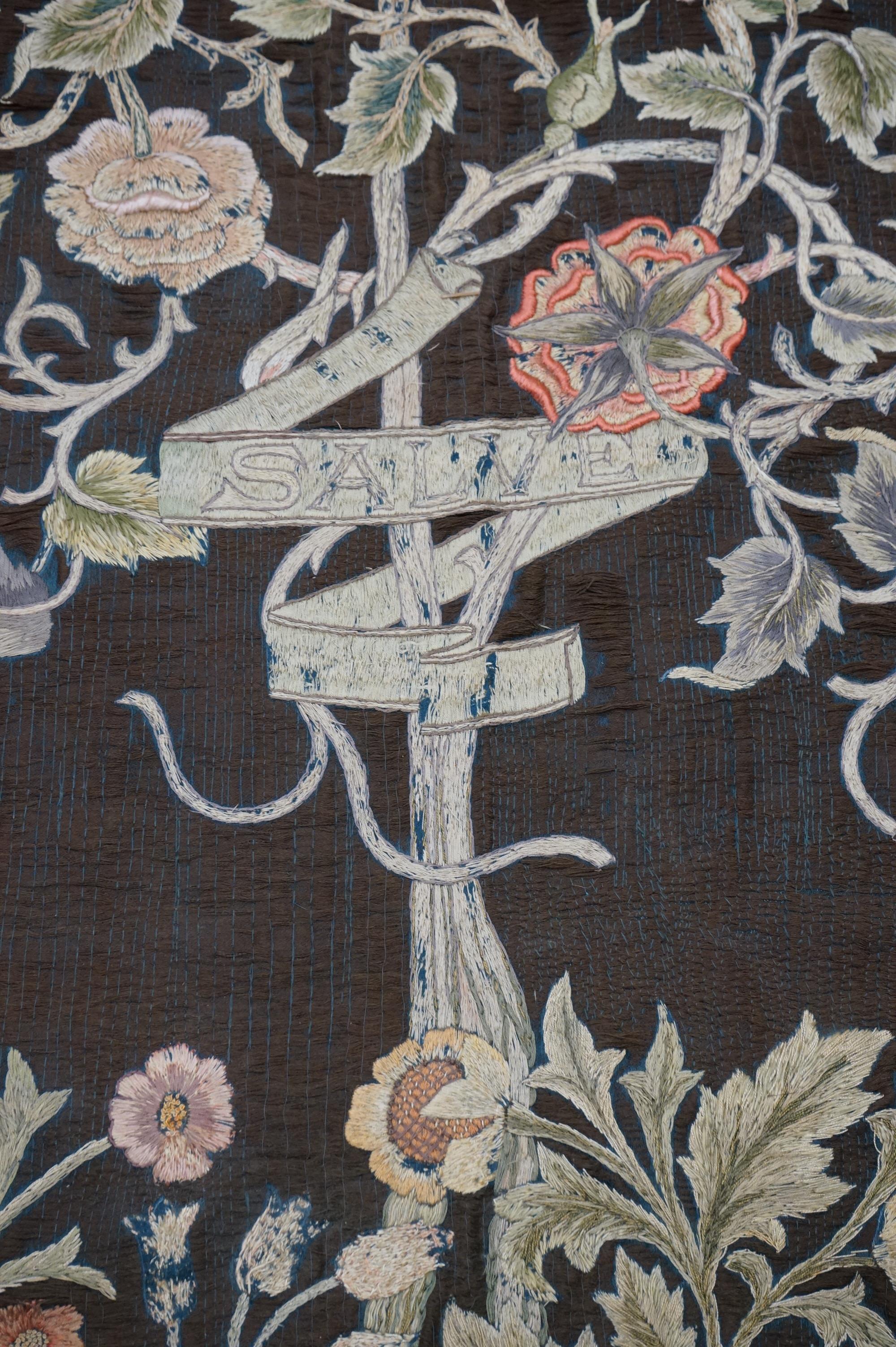 A large Arts and Crafts silk embroidered wall hanging, embroidered in the manner of May Morris with a large central scrolling flowering rose tree and banner embroidered with Salve and a two row motto below;, Rose leaves